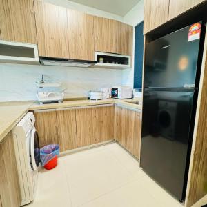振林山Forest city Sea view homestay的厨房配有黑色冰箱和木制橱柜。