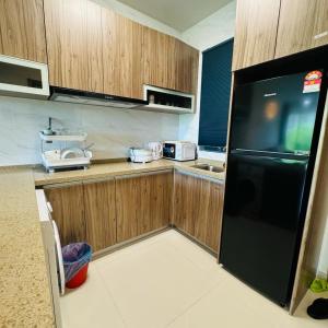 振林山Forest city Sea view homestay的厨房配有木制橱柜和黑色冰箱。