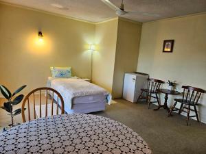 蒂阿瓦穆图公园汽车旅馆的一间卧室配有一张床铺、一张桌子和一台冰箱