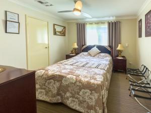 珀斯阿斯科特天鹅住宿加早餐旅馆的一间卧室配有一张床、两盏灯和一个窗户。