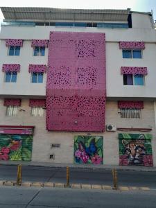 卡利HOTEL SAN ANTONIO PLAZA的一面有粉红色墙的建筑