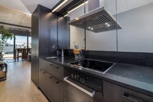 金斯顿Stunning 1BR Apartment with Water Views的厨房配有黑色台面和炉灶