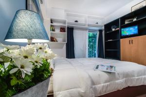 雅典Cozy Apartment in Athens 3 km from Acropolis, 5km form the beach的一间卧室配有白色花卉和灯床