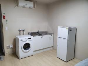 Wando莞岛尼西亚宾馆的厨房配有洗衣机和水槽