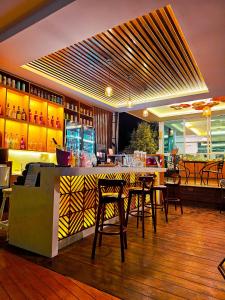 清刊Chiangkhan River Mountain Resort的餐厅设有酒吧,配有桌椅