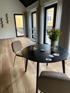 洛肯Kallehavegaard Badehotel的客厅配有一张黑桌子和椅子