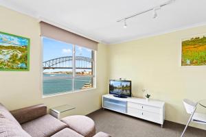 悉尼Harbour View with Opera House Overlook的带沙发和电视的客厅