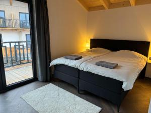 黑马戈尔Chalet near Nassfeld ski resort in Carinthia的一间卧室设有一张床和一个大窗户