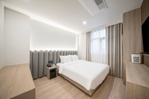 庆州Gyeongju Poverta Hotel的酒店客房设有白色的床和窗户。