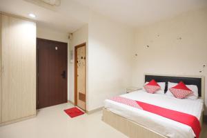 巴淡岛中心OYO 93667 Penginapan Pelangi的一间卧室配有红色和白色枕头的床