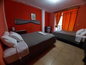 帕纳哈切尔Casa de Alondras的红色墙壁客房的两张床