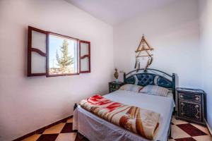 西迪考乌奇Ayour Hostel的一间卧室设有一张床和一个窗口