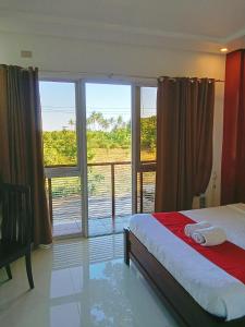 公主港Royale Parc Hotel Puerto Princesa Palawan的一间卧室设有一张床和一个大窗户