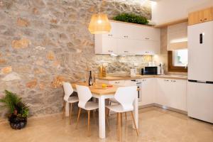 AnópolisSweet memories in amazing Villa Eualia w pool的厨房配有木桌和白色椅子