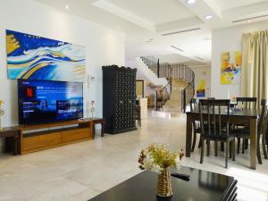迪拜Villa Room #6 in Umm Al Sheif的带电视的客厅和用餐室