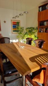 DrachenbronnLa Maison des Roses的一张木桌,房间周围摆放着椅子