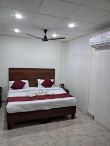 哈里瓦Hotel Bhajgovindam的一间卧室配有一张带红色枕头的大床