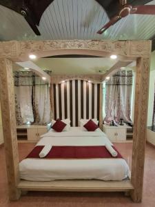 哈里瓦Hotel Bhajgovindam的大卧室配有一张带红色枕头的大床