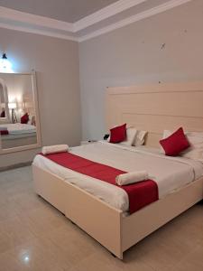 哈里瓦Hotel Bhajgovindam的一间卧室配有一张带红色枕头的大床