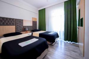 开塞利seyir royal的配有绿窗帘的酒店客房的两张床