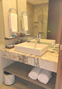 OraniMagarra Hotel的一间带水槽和大镜子的浴室