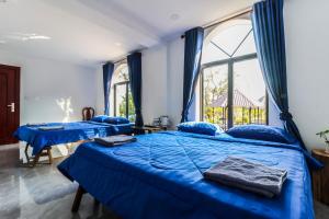 贡布Kampot Hill Lodge的带窗户的客房内的2张蓝色的床