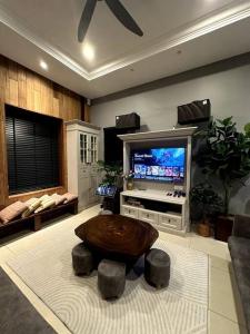 怡保YouLuvHomestay Ipoh的客厅配有桌子和电视