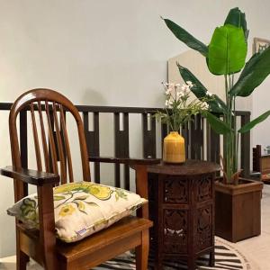 怡保YouLuvHomestay Ipoh的木椅和花瓶桌子