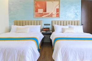 OraniMagarra Hotel的蓝色墙壁客房的两张床