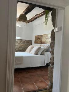 Puebla de ArenosoCasa Rural La Garcia的一间卧室设有一张床和石墙