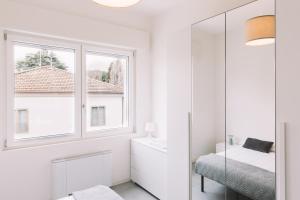 伊莫拉Appartamenti Autodromo的白色的浴室设有镜子和窗户