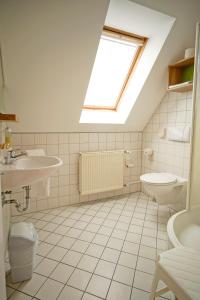 比勒费尔德Hotel Lindenhof的浴室配有盥洗池和天窗。