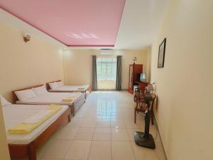 洞海Hải Yến Hotel Quảng Bình的带三张床和紫色天花板的客房