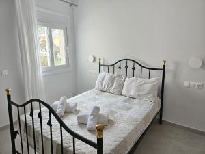 阿普索斯NAVSIKA LUXURY APARTMENT的一间卧室配有黑色床、白色床单和枕头
