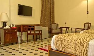 LāejaVijay Vilas Heritage Resort的酒店客房配有一张床、一张书桌和一台电视。