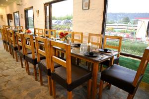 兰纳加Corbett Tiger Retreat的用餐室配有长木桌子和椅子