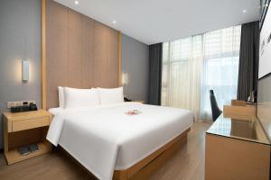广州宜致酒店(广州珠江新城体育西路地铁站店)的卧室设有一张白色大床和一扇窗户。