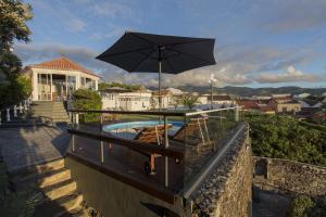 大里贝拉奎尼塔罗萨别墅酒店的一个带遮阳伞和椅子的庭院和一个游泳池