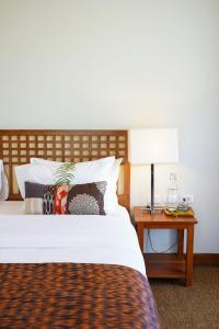 爱妮岛Pandan Villas, El Nido的一间卧室配有一张床和一张带台灯的桌子
