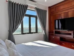波来古市Đoàn Gia Luxury House的一间卧室设有一张床、一台电视和一个窗口。