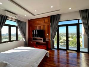 波来古市Đoàn Gia Luxury House的一间卧室设有一张床、一台电视和窗户。