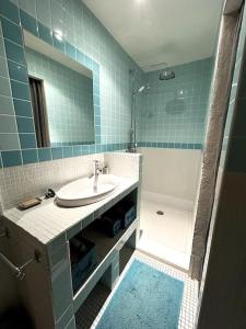 阿尔勒"Le couvent bleu" Arles arènes Terrasse的蓝色瓷砖浴室设有水槽和浴缸
