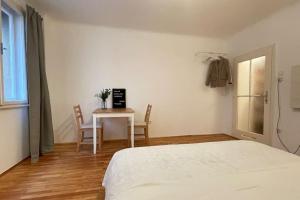 维也纳mariahilfer street apartment的一间卧室配有一张床和一张桌子及椅子