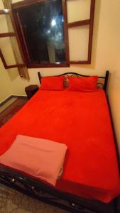 马拉喀什Residence Gharnata app 11 imm I的红色的床,配有红色枕头和窗户
