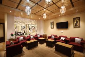 西姆拉Fortune Park Kufri, Shimla - Member ITC's Hotel Group的一间设有红色沙发和平面电视的等候室