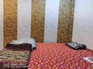 马图拉Kadiya dharamshala的卧室配有一张床和被子,位于地板上