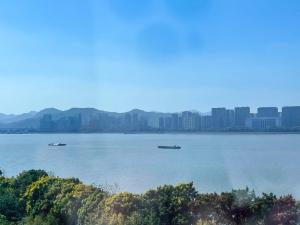 杭州乐享家·江景影院民宿(星光大道金铂湾店)的两艘船在水面上,以城市为背景