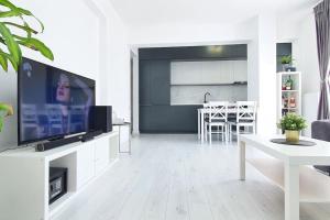 Popeşti-Leordeni100 sqm flat -Netflix/Coffee/Garage/2xBath/2xTV的带电视的白色客厅和厨房