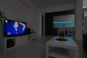 Popeşti-Leordeni100 sqm flat -Netflix/Coffee/Garage/2xBath/2xTV的客厅配有平面电视和桌子。