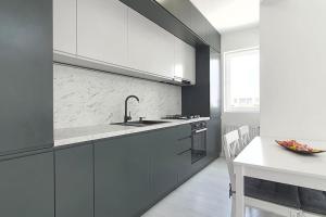 Popeşti-Leordeni100 sqm flat -Netflix/Coffee/Garage/2xBath/2xTV的厨房配有白色橱柜、水槽和桌子